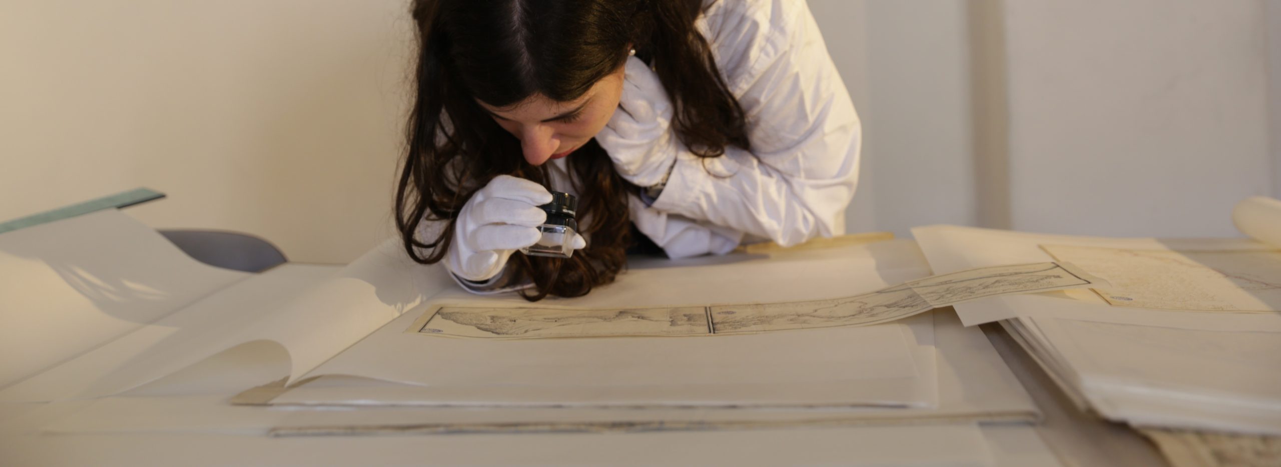 Ragazza che studia archivio con lente